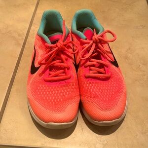 Neon pink Nike running shoes. In good condition.